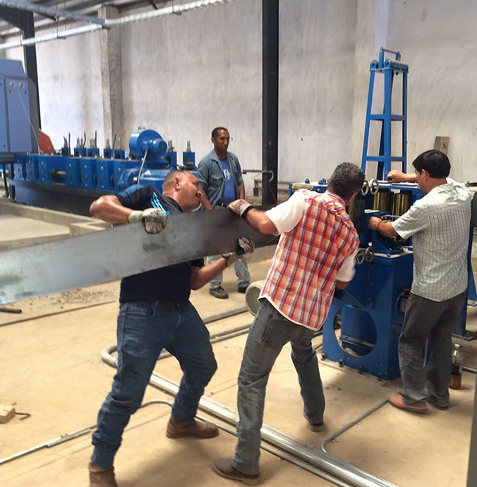 Trabajadores manipulando una pieza de acero en una planta industrial
