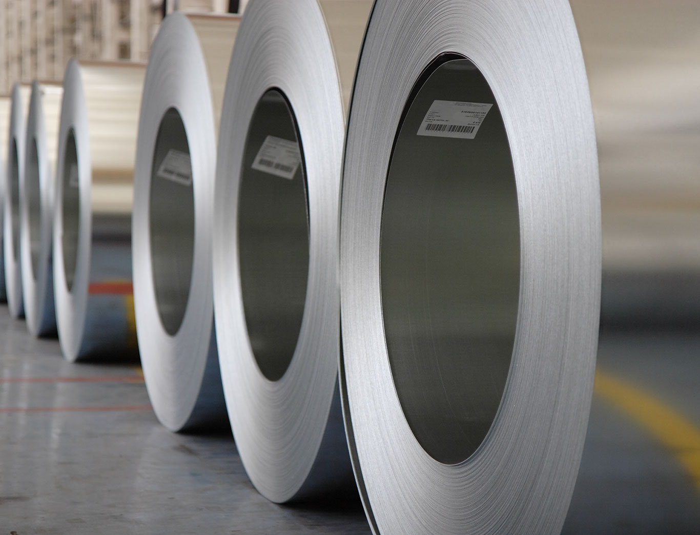 Rollos de lámina de acero alineados en una planta industrial